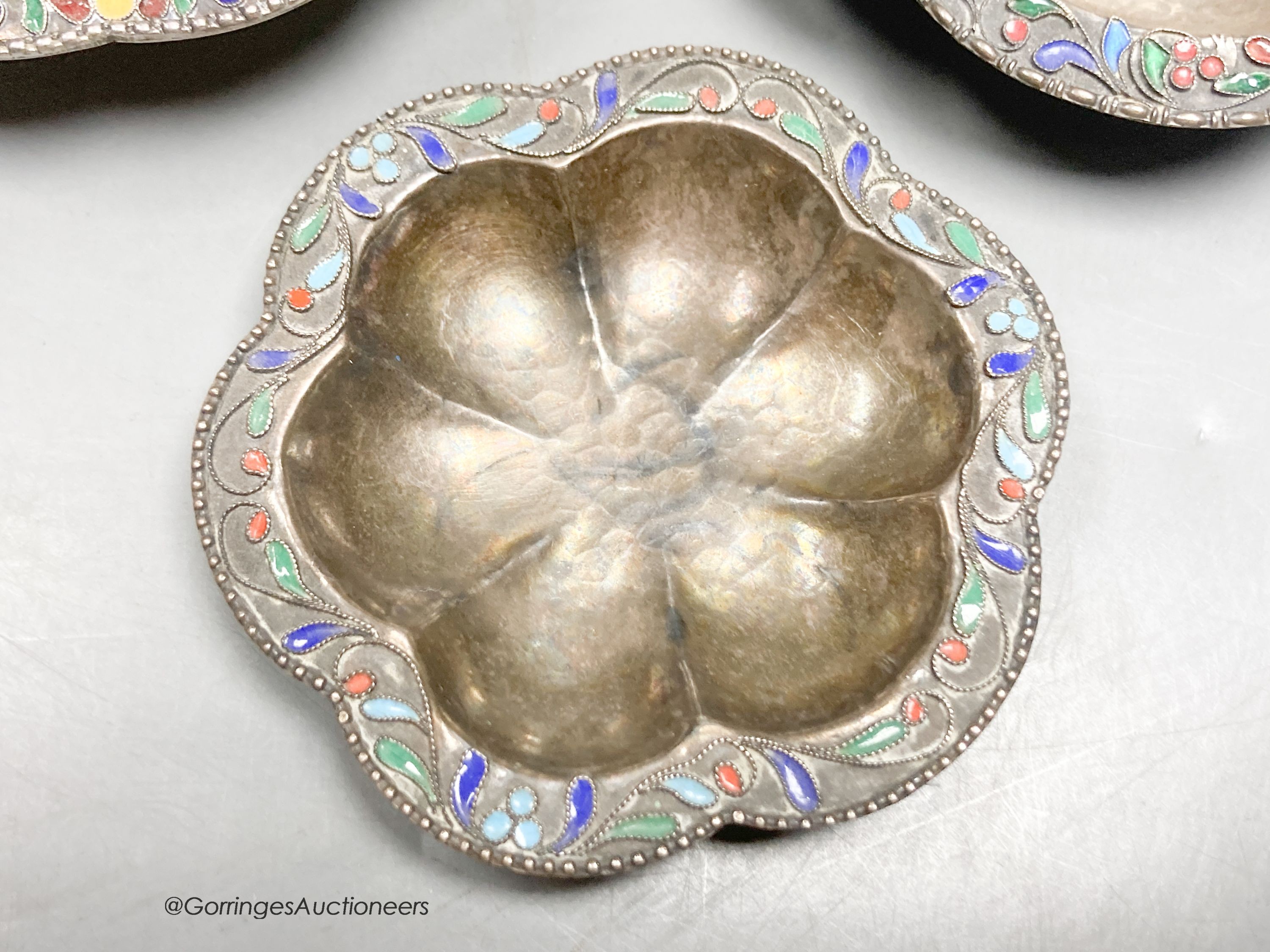 Three Persian white metal and cloisonne enamel small dishes, largest 9.6cm, gross weight 89 grams.